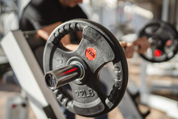 Obraz premium Close up on lifting weights with barbell at gym
