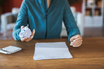 woman work from home and hold crumpled paper ball for the trash