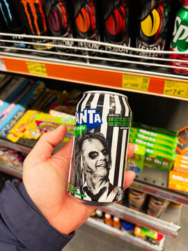 Kyiv, Ukraine - February 04, 2025: Person holding a Fanta themed drink can in a beverage section of a store