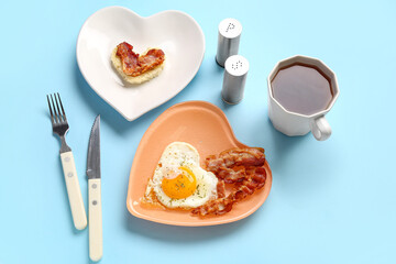 Composition with tasty bacon, fried egg, bread and cup of tea on blue background