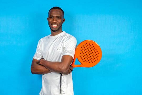 Smiling athlete holding orange padel racket