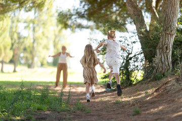 Children joyfully running toward parent in forest