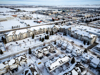 Snowy cityscape with a mix of residential and commercial buildings