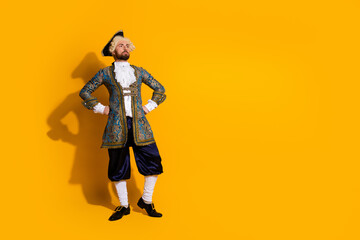 Aristocratic man in historic style costume posing confidently against a vibrant yellow backdrop