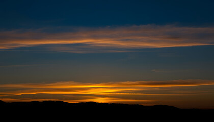Obraz premium Sunset with the silhouette of mountains, dramatic atmosphere. with white shades