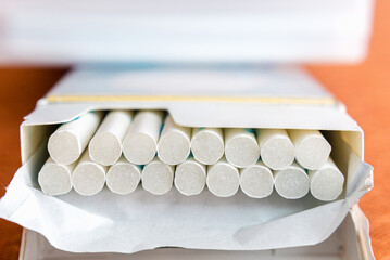 Open pack of cigarettes with close-up of several cigarettes white filter.
