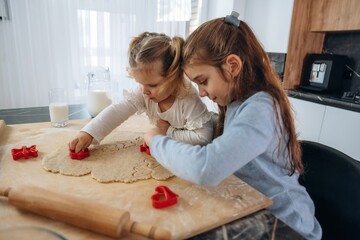 Side view, busy. Two little girls are preparing bakery at home