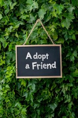 Illustration of a cheerful "Adopt a Friend" signboard at an event