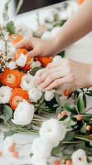 Hands arranging vibrant orange and white flowers in a delicate floral bouquet