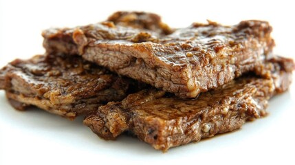 Close up view of seasoned meat slices, stacked on a white surface, showing brown and dark brown colors, and a glossy texture. Slices appear to be