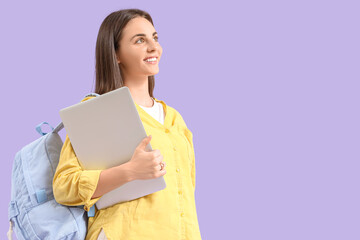 Obraz premium Female student with backpack and laptop on lilac background