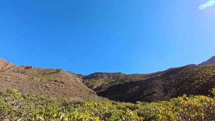 schroffe Berggipfel unter blauem Himmel, Sonne, idyllische Berge, Berghang, Lanzarote, Kanaren,...