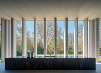 Fototapeta premium Modern concrete interior kitchen, featuring large windows showcasing a verdant landscape, dark speckled countertop, and minimalist design