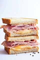 Delicious stack of ham, cheese, and sandwiches on a white background.
