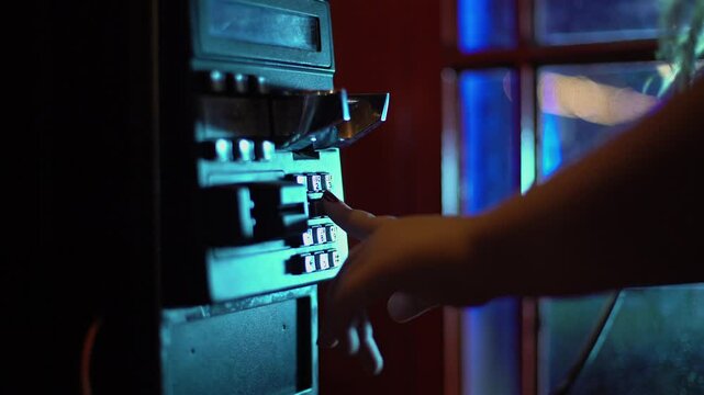 A woman calls from an old telephone booth on the street