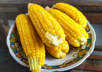Closeup. Fresh steamed sweet corn with bright yellow color serving on plate. Healthy food. Selective focus.
