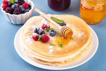 Traditional Maslenitsa food, Eastern European Slavic thin pancakes crepes, with various sweet spreads, toppings and fillings - honey, berries, jams 
