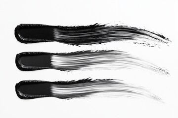 Fototapeta premium Three artistic black paint strokes on a clean white background.