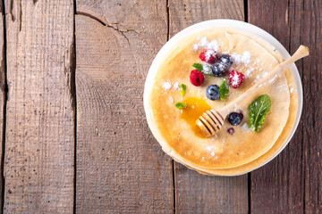 Traditional Maslenitsa food, Eastern European Slavic thin pancakes crepes, with various sweet spreads, toppings and fillings - honey, berries, jams 