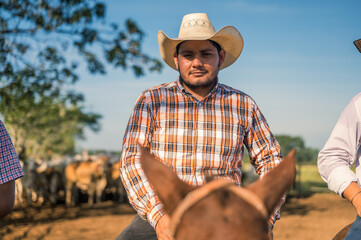 Portrait of a young cowboy. The cowboy looks proudly at the camera.