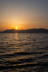 Fototapeta premium View of the sunset over the sea and island