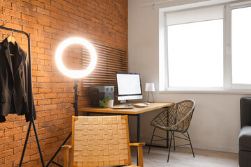 Interior of clothing store office with workplace, rack and armchair
