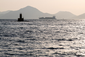 beacon and cargo ship on the sea