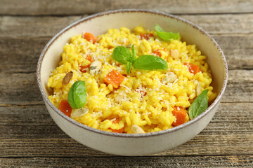 Delicious pumpkin risotto in bowl on wooden table, closeup