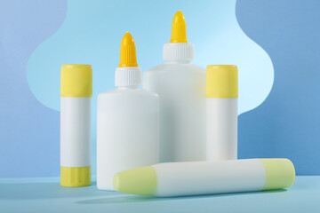 Different types of glue and paper cutouts on light blue background