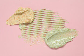 Samples of different body scrubs on pink background, top view