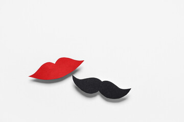 Male mustache and female lips made of paper isolated on white background