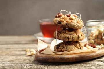 Tasty cookies with nuts on wooden table, space for text