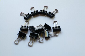 Arrangement of Black Binder Clips on a White Surface Creating a Modern and Clean Aesthetic