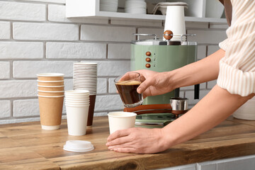 Young female barista making coffee with coffee machine in coffee shop