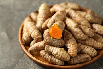 Raw tumeric rhizomes on grey table, closeup