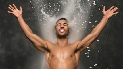 Man celebrating with arms raised, surrounded by splashes of powder, expressing joy and freedom in dynamic pose. scene captures exhilarating sense of liberation