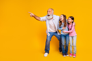 Grandfather Enjoying Bonding Time with Excited Grandchildren on Vibrant Yellow Background