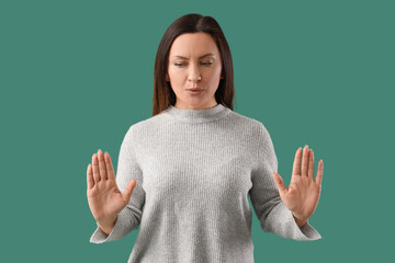 Worried woman trying to calm down on green background