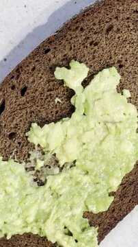 Preparing a healthy spread on brown bread for breakfast