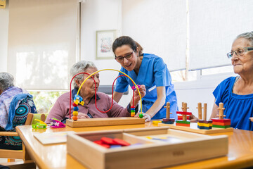 Nurse assisting elderly woman with cognitive games in nursing home