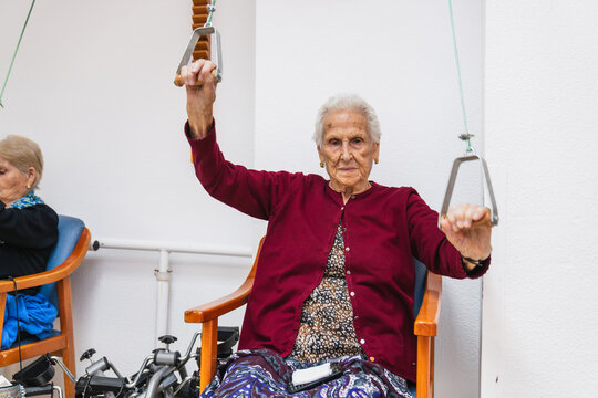 Senior woman exercising with resistance bands in nursing home