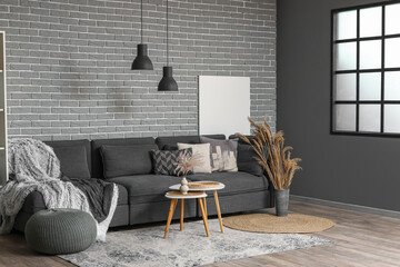 Large sofa, pouf and coffee table in interior of living room