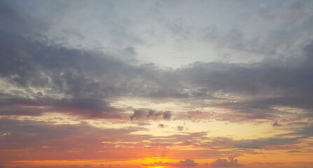 Sunset sky background. Colorful gold sky with clouds and sun light