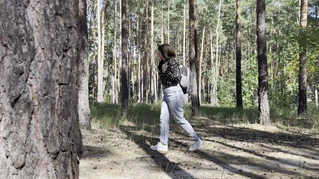 Woman walks through forest with cat in a carrier