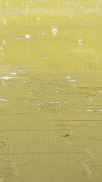 Raindrops create patterns on yellow surface
