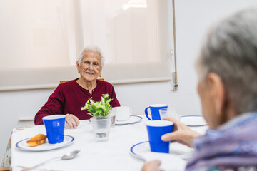 Elderly residents enjoying meal together in nursing home