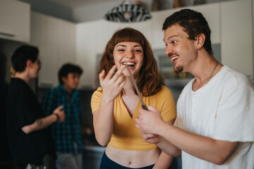 A close-up of two cheerful friends sharing a fun and playful moment in a modern kitchen setting.