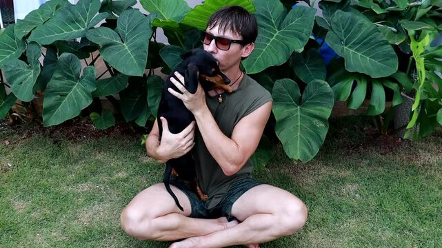 homem faz carinho em cachorro dom&eacute;stico 