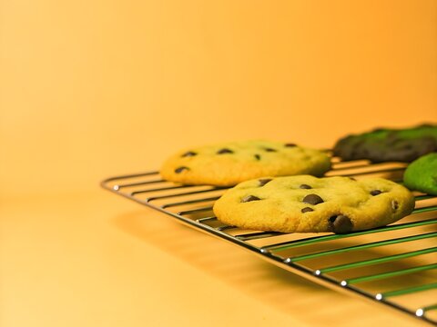 A close-up shot of freshly baked chocolate chip cookies on a cooling rack