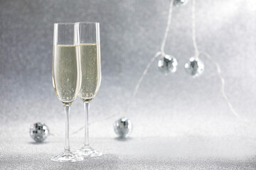 Champagne in glasses and decor on silver background. Space for text